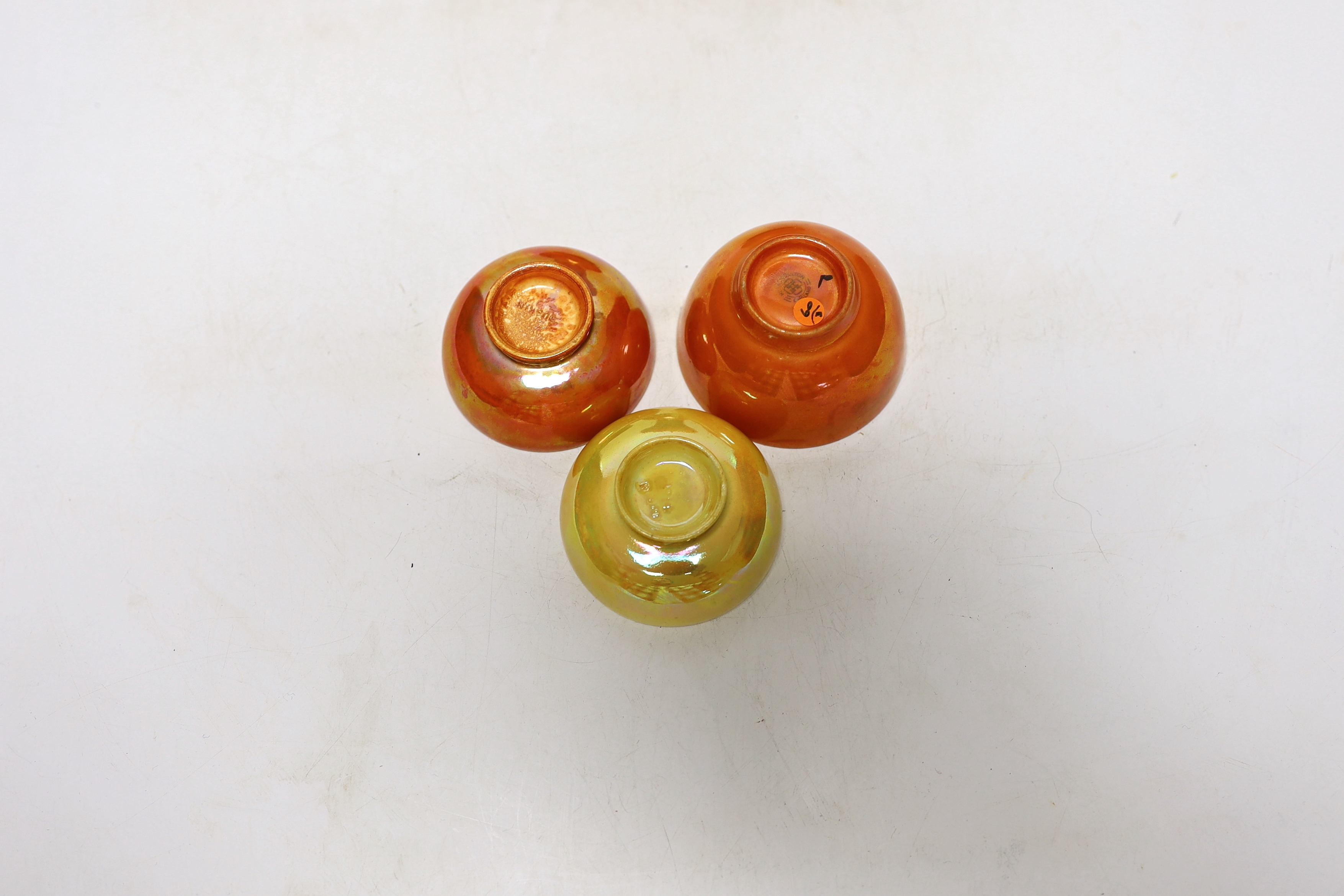 A Ruskin orange glazed vase (a.f) and three similar small bowls by Ruskin and Doulton, vase 23.5cm